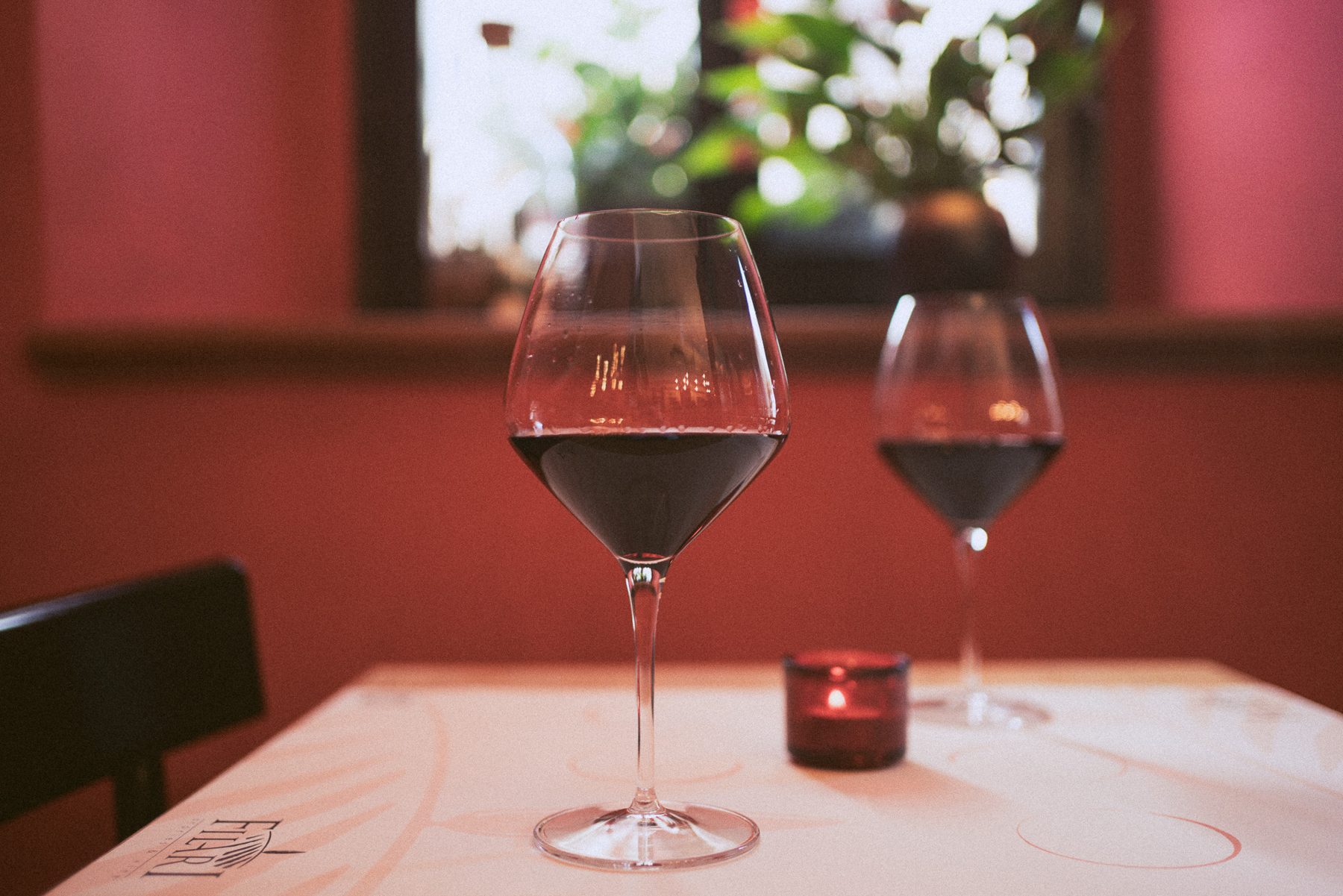 Due calici di vino rosso sulla tovaglia bianca